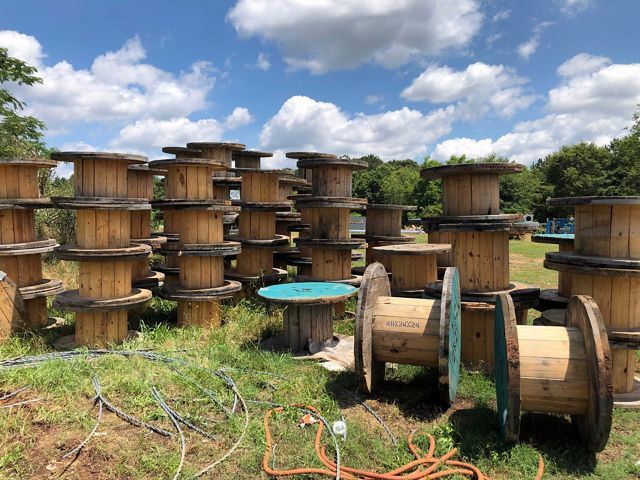 a stack of large wooden spools used for shipping.